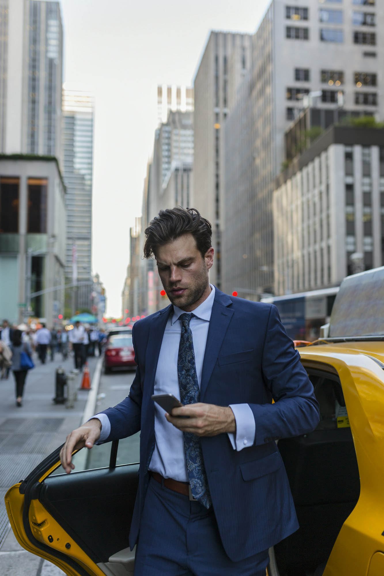 Businessman exiting yellow taxi in Manhattan