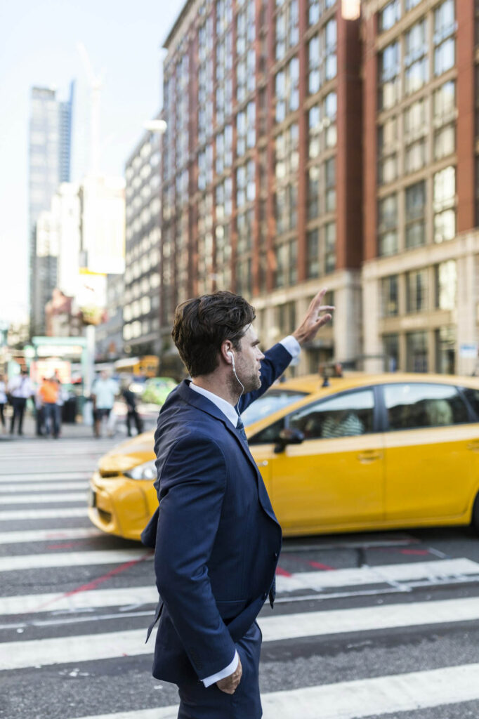 Businessman in the streets of Manhattan hailing a cab